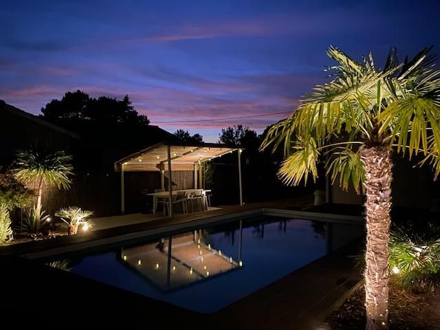 Vue nocturne de la piscine et de la pergola Vue nocturne de la piscine et de la pergola