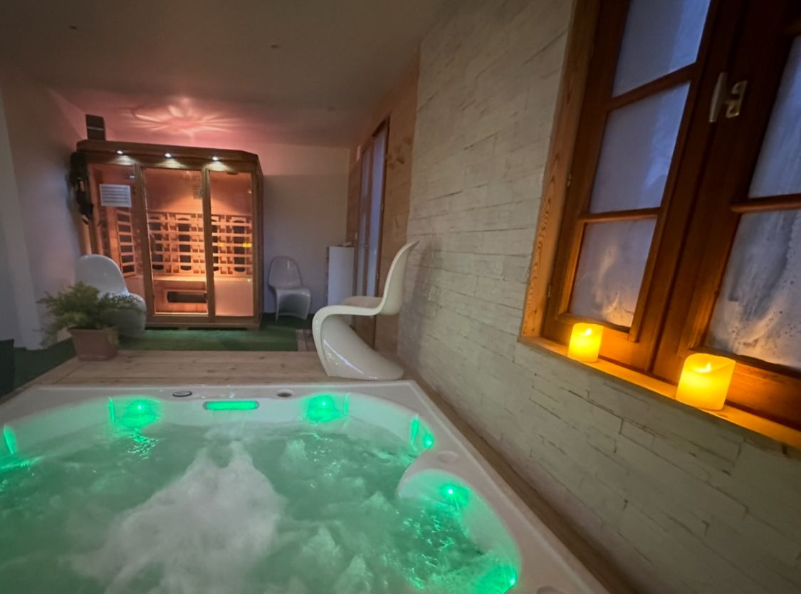 Espace bien-tre avec sauna, un banc de musculation, un vlo elliptique, une douche et un toilette 